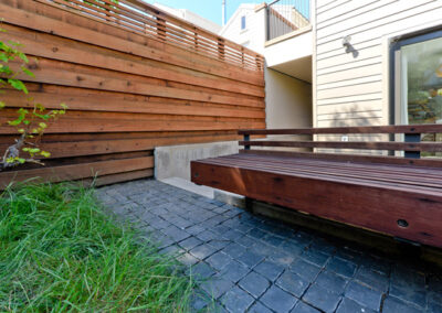 Basalt split-cube cobbles and custom redwood bench.