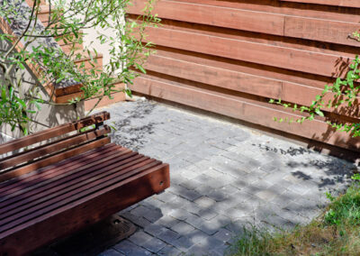 Basalt split-cube cobbles and custom redwood bench.